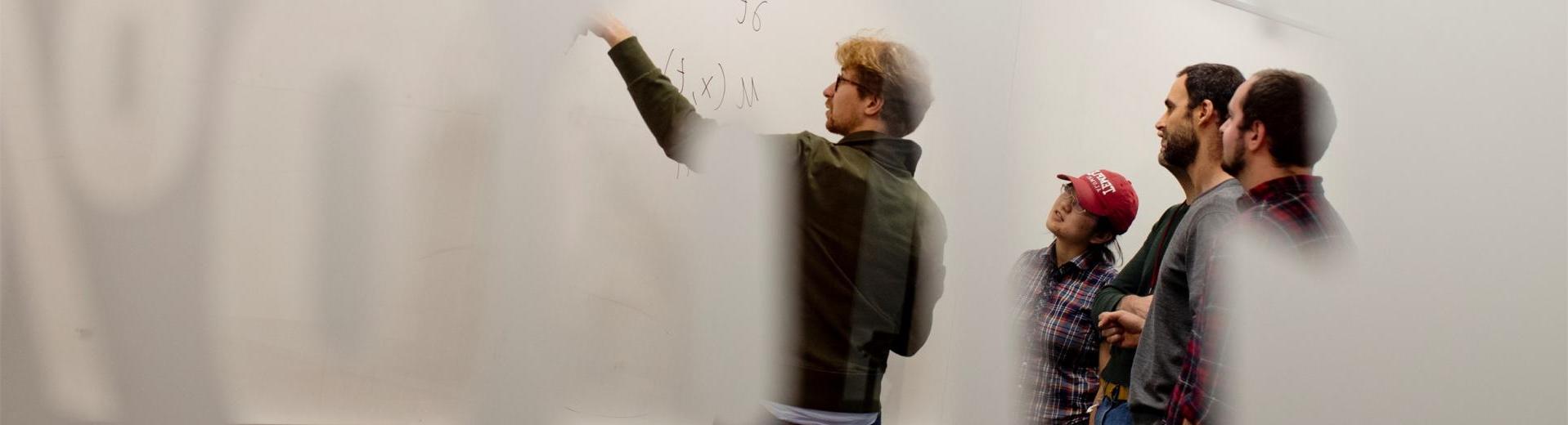 在一所科技学院的教室里，学生们指着白板上的数学方程式.