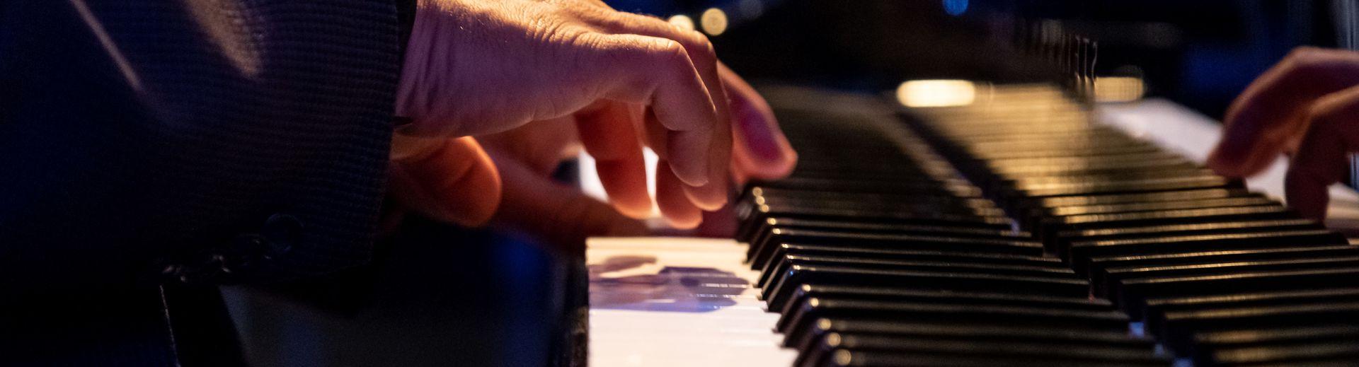 Hands of a pianist on a Steinway grand piano at a performance
