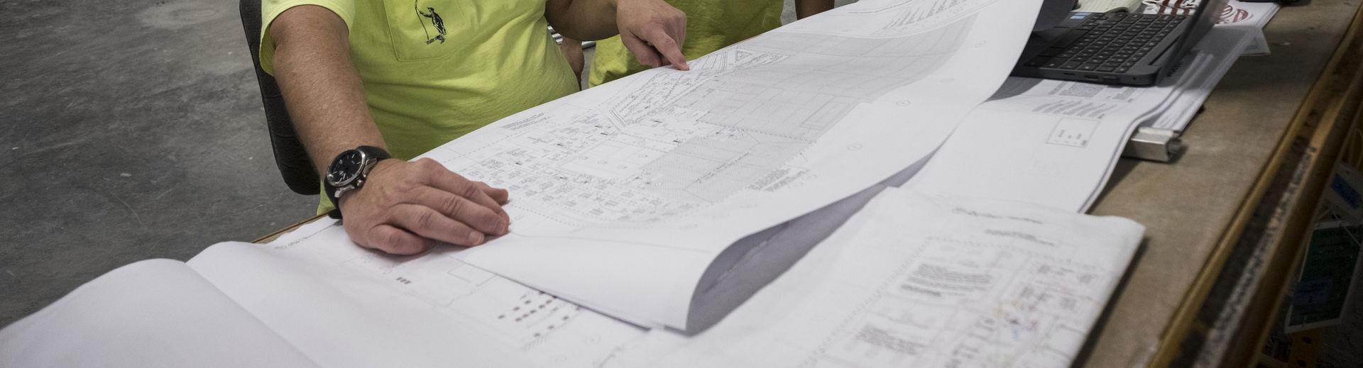 facilities workers reviewing a blueprint of a building. 