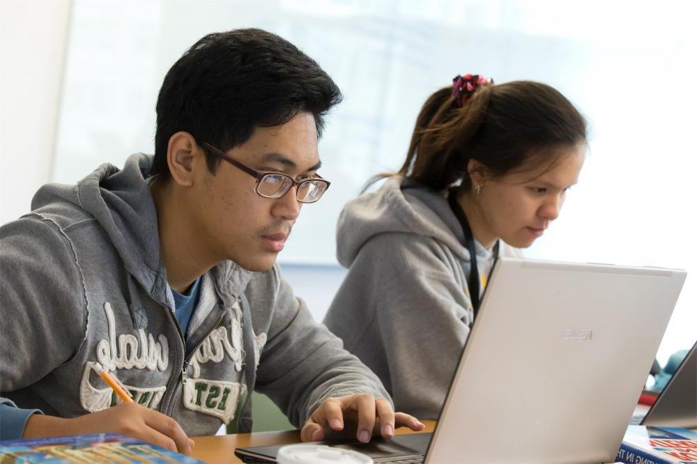两名学生在坦普尔教室的电脑上并肩工作.