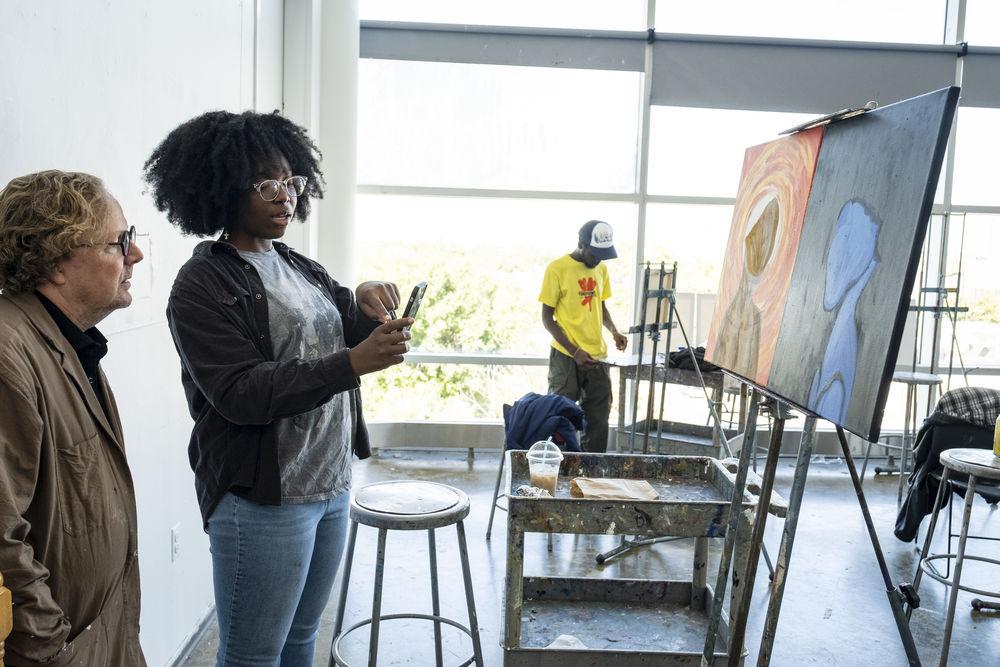 painting student discusses work with professor.